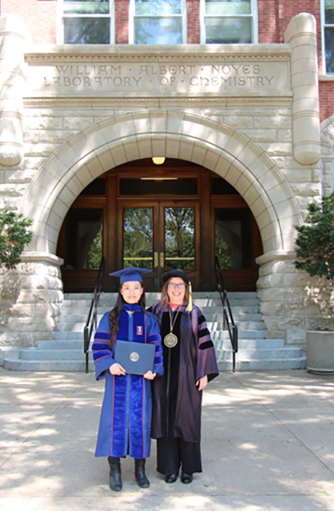 Cathy Murphy and Jingyu Huang in their caps and gowns in front of Noyes Laboratory for Jingyu's graduation, May 2014.